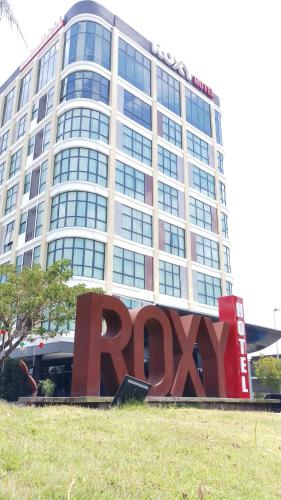 een groot gebouw met een ryan bord ervoor bij Roxy Hotel & Apartments in Kuching
