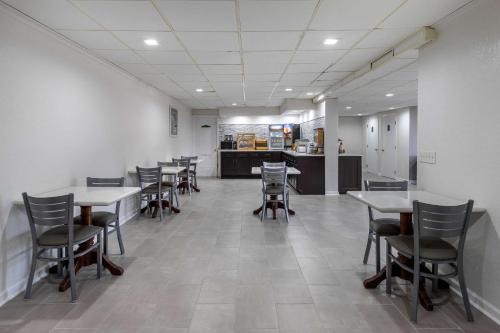 a dining room with tables and chairs and a kitchen at Econo Lodge At The University in Conway