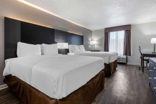 a hotel room with two beds and a desk at Econo Lodge At The University in Conway