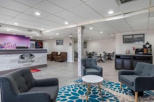 a waiting room with chairs and a table and a counter at Econo Lodge At The University in Conway