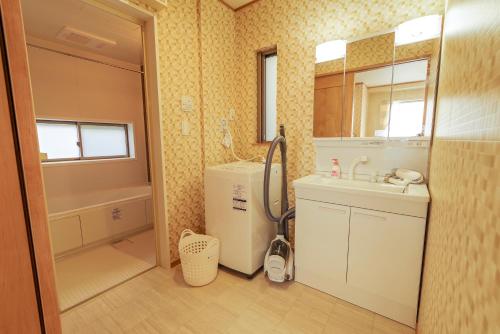 a bathroom with a sink and a toilet and a tub at Hyakuna Terrace in Nanjo