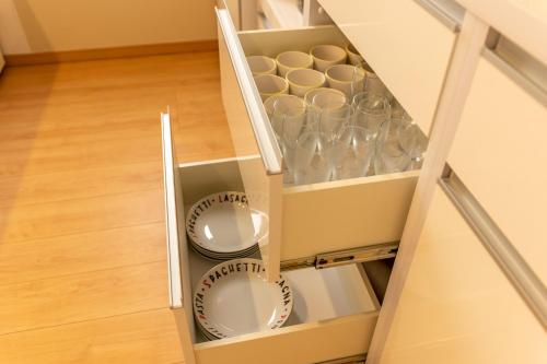 a cupboard with plates and cups in it at Hyakuna Terrace in Nanjo