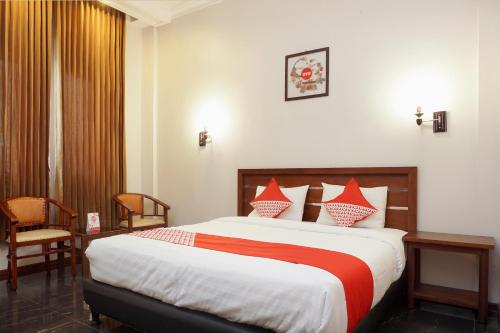 a bedroom with a large bed with red and white pillows at OYO Capital O 514 Omah Pari Boutique Hotel in Yogyakarta