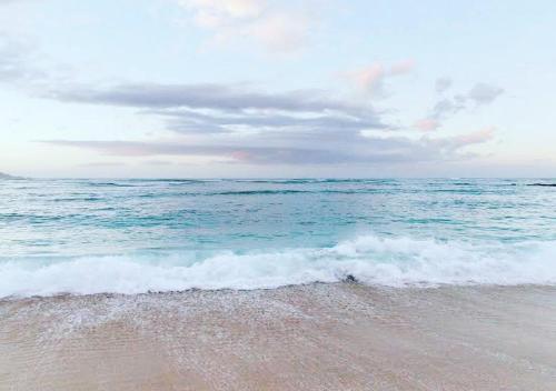 a beach with the ocean and the waves at Sensom Boutique Bed and Breakfast in Coffs Harbour