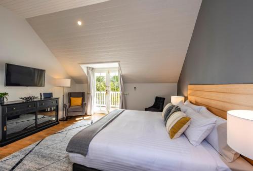 a bedroom with a bed and a desk and a television at Prospect Country House & Restaurant in Richmond