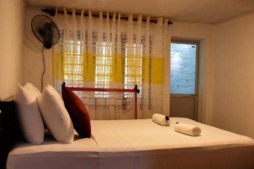 a bedroom with a bed with two towels on it at Rainforest Holiday Inn in Deniyaya