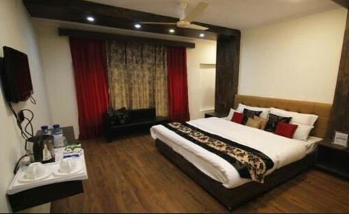 a bedroom with a large bed and a window at Hotel Green Leaf Srinagar in Srinagar