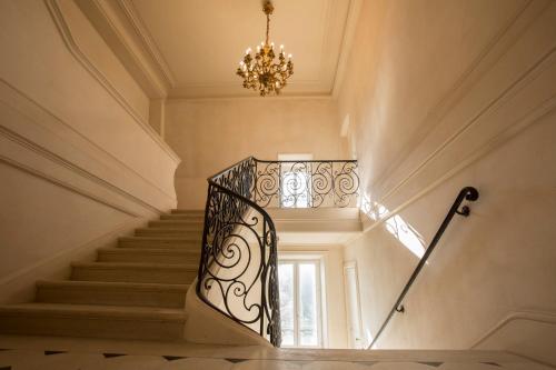 ein Treppenhaus mit Kronleuchter und Wendeltreppe in der Unterkunft Chateau des Monts in Barbeville