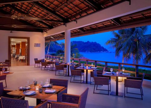 a restaurant with tables and chairs and a view of the ocean at Hyatt Regency Kuantan Resort in Kuantan