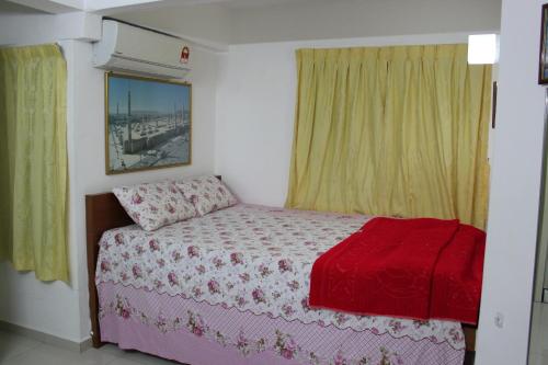 ein Schlafzimmer mit einem Bett mit einer roten Decke in der Unterkunft Macallum Budget Muslim Homestay in George Town