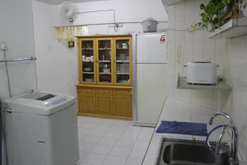 eine kleine Küche mit Spüle und Kühlschrank in der Unterkunft Macallum Budget Muslim Homestay in George Town