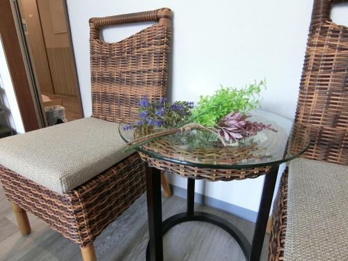 a glass table with a bowl of flowers on it at Alaise De Bale Shirahama in Shirahama