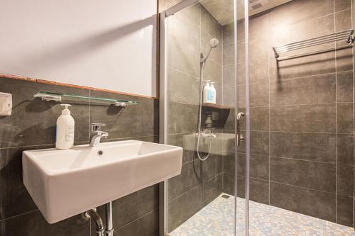 a bathroom with a sink and a shower at mydeer backpacker in Tainan