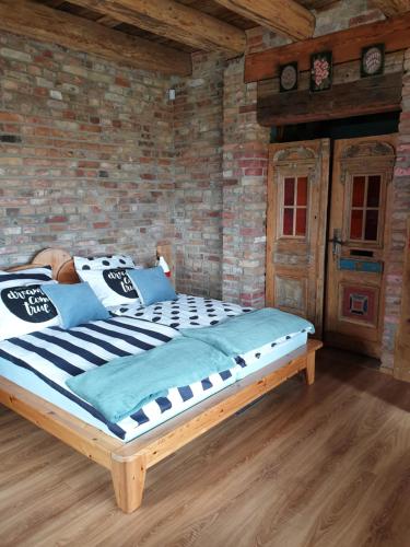 a large bed in a room with a brick wall at DOM GOŚCINNY PTASZARNIA - NATURA-Free PARKING in Świnoujście