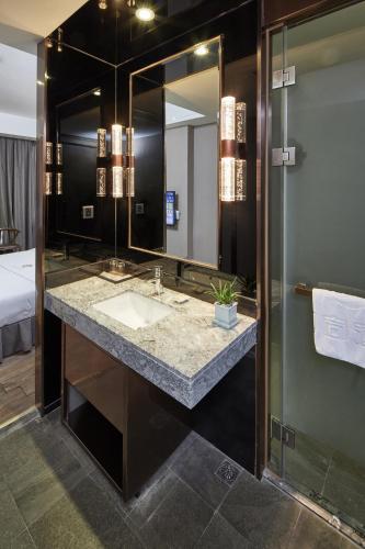 a bathroom with a sink and a mirror at INSAIL Hotel (Shenzhen Dongmen Branch) in Shenzhen