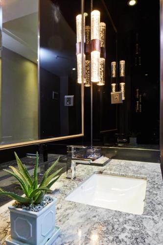 a bathroom with a potted plant and a large mirror at INSAIL Hotel (Shenzhen Dongmen Branch) in Shenzhen