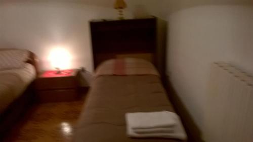 a small room with a bed and a lamp on a table at Angolo Tranquillo in Siano