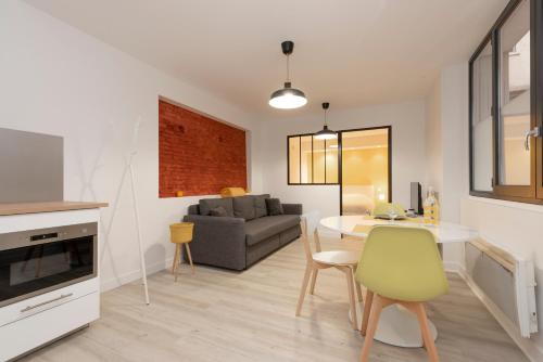 a kitchen and living room with a table and a couch at Lombard in Toulouse