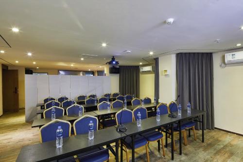 a conference room with a long table and blue chairs at INSAIL Hotel (Shenzhen Dongmen Branch) in Shenzhen