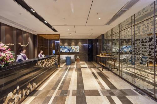 a lobby of a hotel with people sitting at a counter at INSAIL Hotel (Shenzhen Dongmen Branch) in Shenzhen