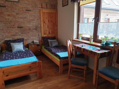 a room with two beds and a desk and a table at DOM GOŚCINNY PTASZARNIA - NATURA-Free PARKING in Świnoujście