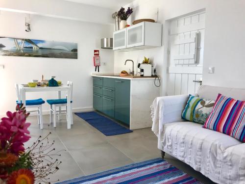 a kitchen and living room with a couch and a table at Casa no Rio - River House in Vila Nova de Milfontes