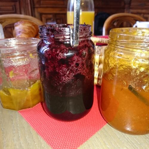 une table avec deux bocaux de confiture et autres liquides dans l'établissement La Maison d'Adelaïde, à Saint-Flour