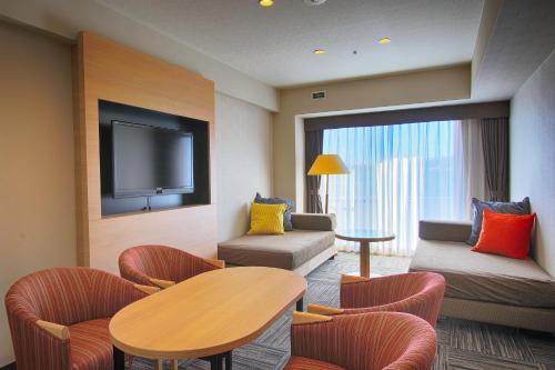 a hotel room with a table and chairs and a tv at Hotel Regina Kawaguchiko in Fujikawaguchiko