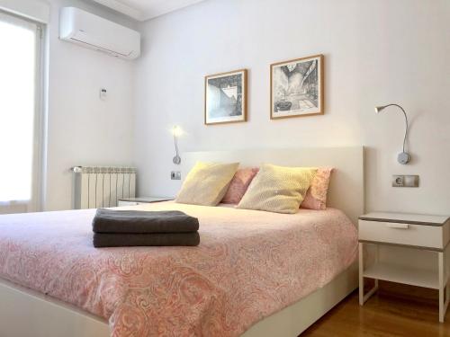 um quarto com uma cama grande com almofadas cor-de-rosa e amarelas em Gros Beach Apartment em San Sebastián