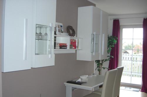 a kitchen with white cabinets and a table at Appartement Am Goldberg in Goldbach