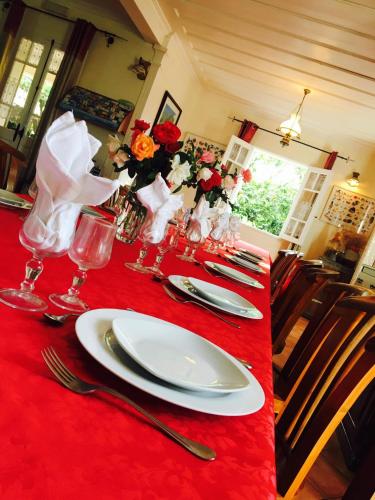 a red table with a white plate on a red table at Relais Des Gouverneurs in Salazie