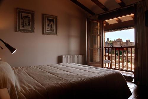 a bedroom with a bed and a large window at Hotel Villa de Alquézar in Alquézar
