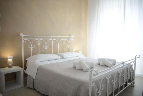 Un dormitorio con una cama blanca con almohadas y una ventana en B&B Alghero 82 en Alghero