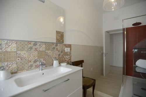 La salle de bains est pourvue d'un lavabo et d'une douche. dans l'établissement B&B Alghero 82, à Alghero