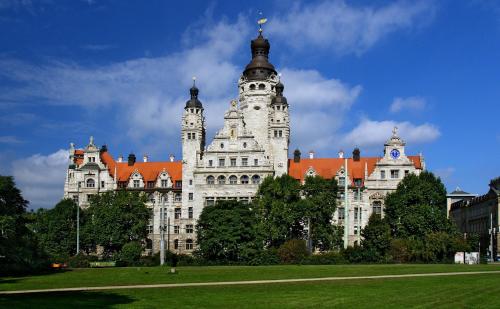 ein großes weißes Gebäude mit rotem Dach in der Unterkunft Mitten in Leipzig Wohnung 1 in Leipzig