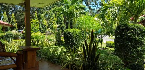 a garden with plants and trees and a porch at Mountain View Cottages in Mambajao