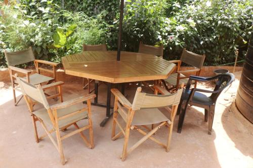 een houten tafel en stoelen op een patio bij Preston Pointe Resort in Kisii