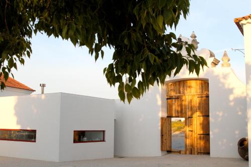 a house with white walls and a wooden door at Quinta da Lapa in Manique do Intendente