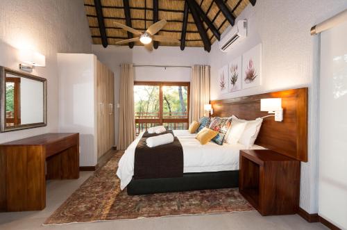 a bedroom with a large bed and a mirror at Kruger Park Lodge Unit No. 611 in Hazyview