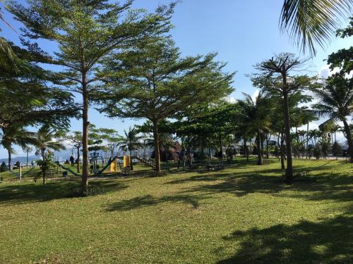a park with palm trees and a playground at Moonlight Bay Hotel & Apartment in Nha Trang