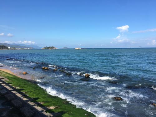 a large body of water with rocks in the water at Moonlight Bay Hotel & Apartment in Nha Trang