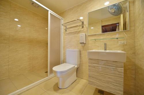 a bathroom with a toilet and a sink and a shower at Shinmingshan Holiday Inn in Lugu