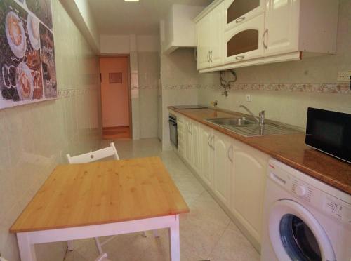 une cuisine avec un évier et une machine à laver dans l'établissement Apartment Poeta Aleixo in Faro, à Faro