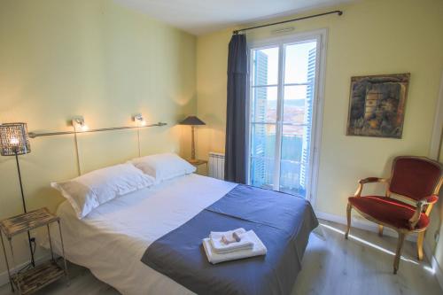 une chambre avec un lit, une chaise et une fenêtre dans l'établissement La Providence Nice, à Nice