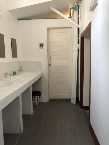 a bathroom with two sinks and a white door at PLOY Hostel in Bangkok