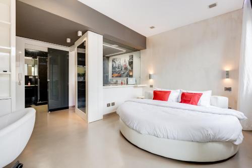 una grande camera da letto bianca con un grande letto con cuscini rossi di EMERALD Luxury Suite Apartment a Roma