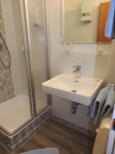 a bathroom with a sink and a shower at Hotel Carossa bed&breakfast in Sankt Gilgen