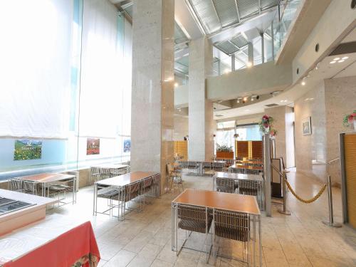 a restaurant with tables and chairs and large windows at APA Hotel Toyama Ekimae in Toyama