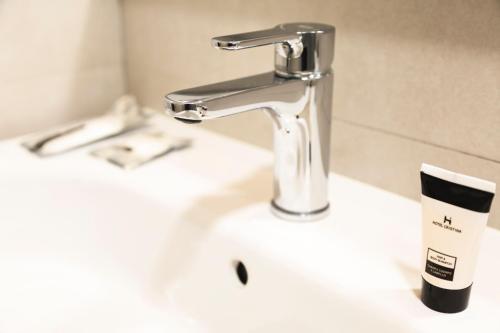 a sink with a faucet and a cup on it at Hotel Cristina in Los Alcázares
