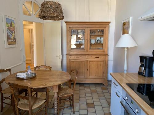 a kitchen with a wooden table and a wooden cabinet at L'Annexe Apparthôtel du 11 A, 4 étoiles in Besançon